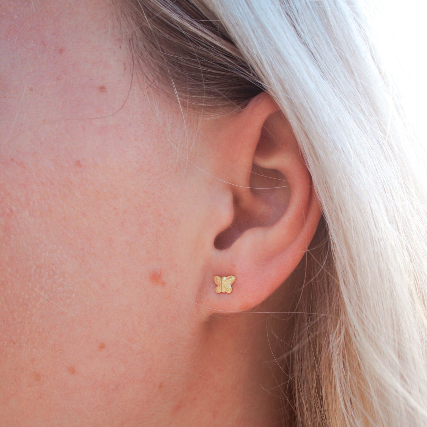 Model showcasing butterfly stud earrings in 14K gold filled—elegant, delicate design that adds a touch of whimsy and sophistication to any look.