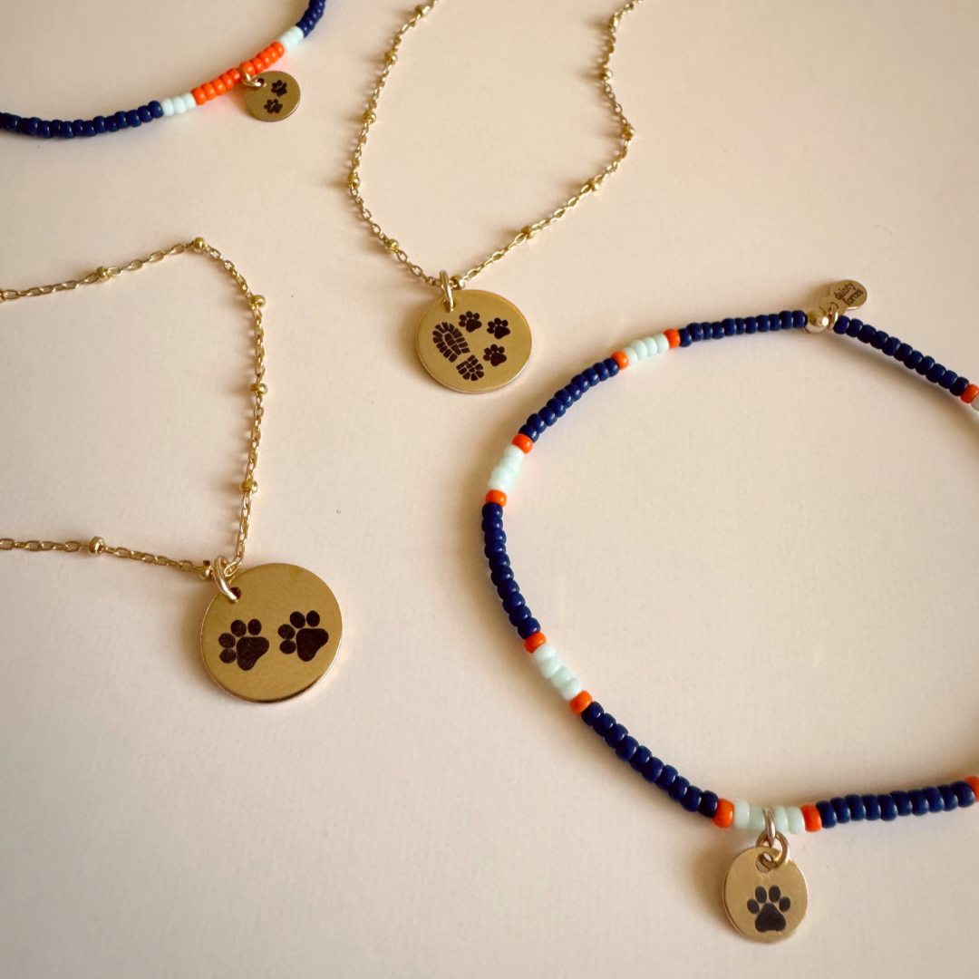 Necklaces with paw print charms on a light background