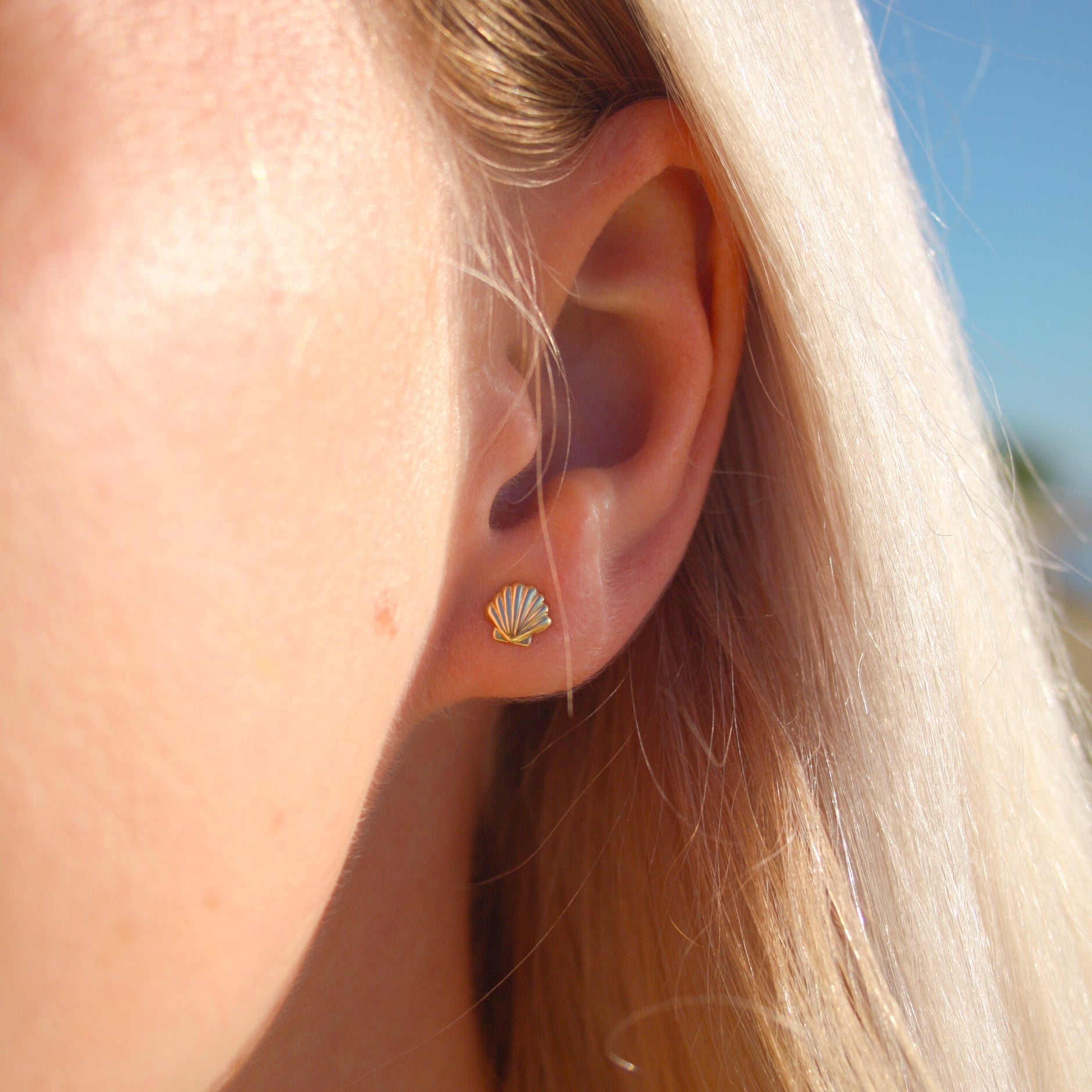 Shell Stud Earrings on a model at the beach – dainty, ocean-inspired jewelry captured in a close-up, perfect for adding coastal elegance to your style. Shop unique beach-themed earrings today