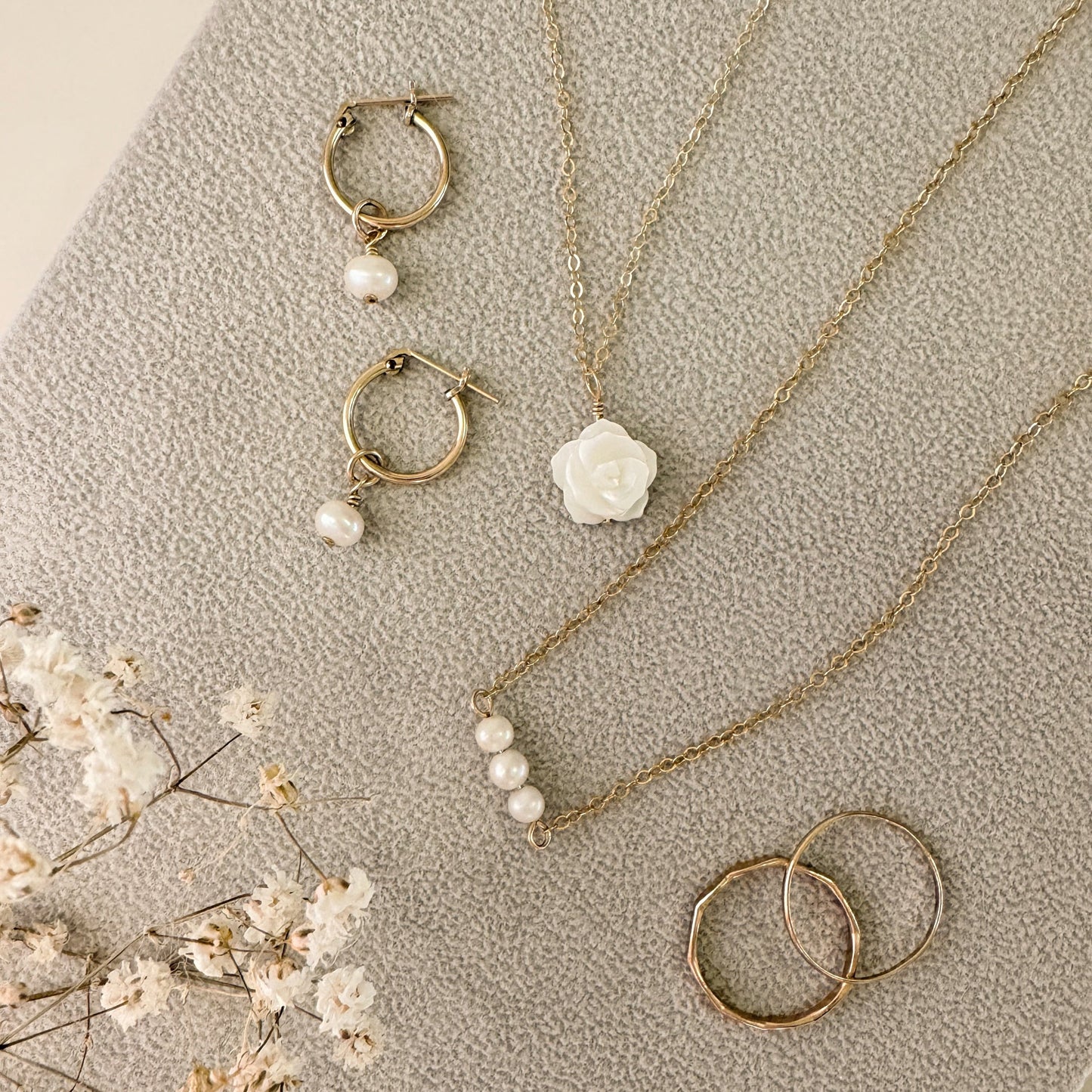 The Rose Necklace, The Camille Necklace, and the Pearl Charmed Earrings – a stunning collection of dainty, handcrafted jewelry featuring timeless pearls and elegant designs. Perfect for layering or wearing alone to elevate any look. Shop these versatile pieces today!