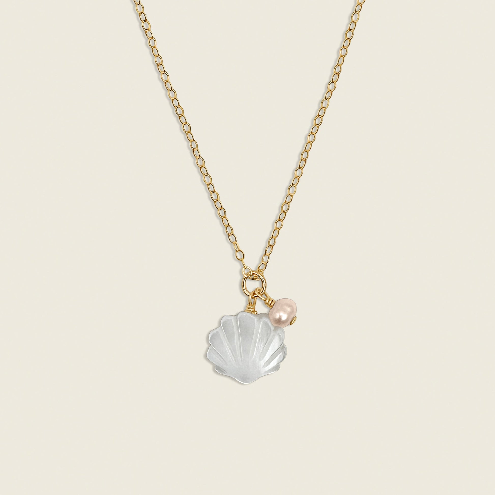 The Sylvia Necklace – featuring a Mother of Pearl shell charm paired with a pink freshwater pearl in 14K Gold Filled. A delicate and elegant accessory perfect for adding a touch of coastal charm to your style