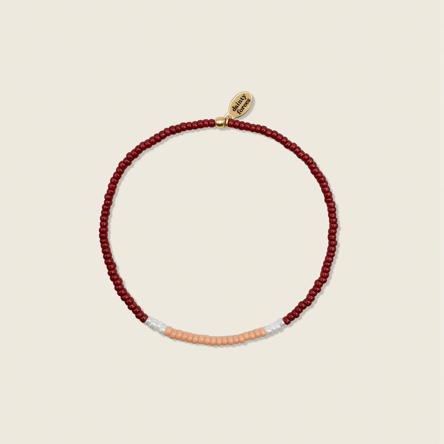 A beaded bracelet with red, light peach, and white pearls miyuki beads, displayed against a neutral background.