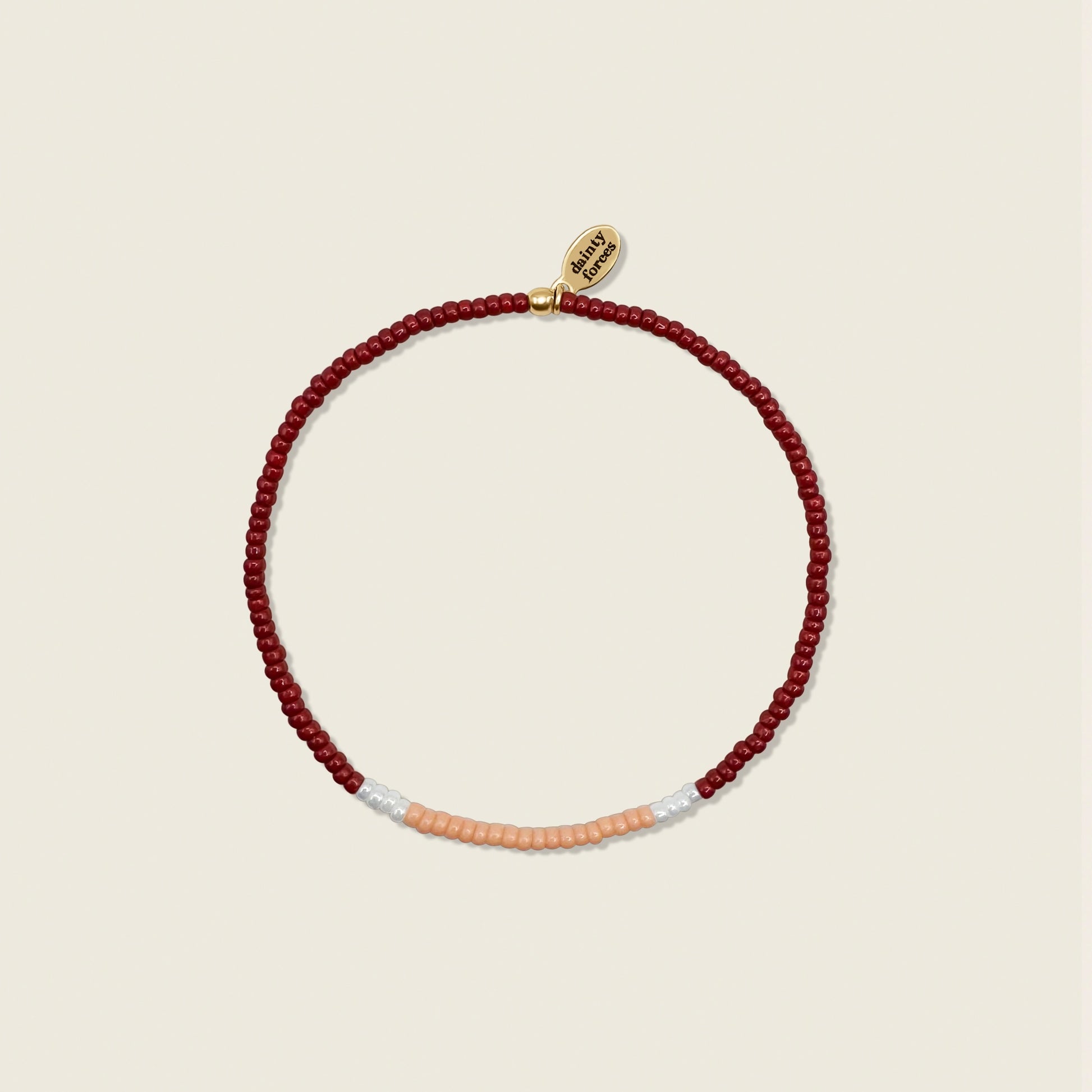 A beaded bracelet with red, light peach, and white pearls miyuki beads, displayed against a neutral background.