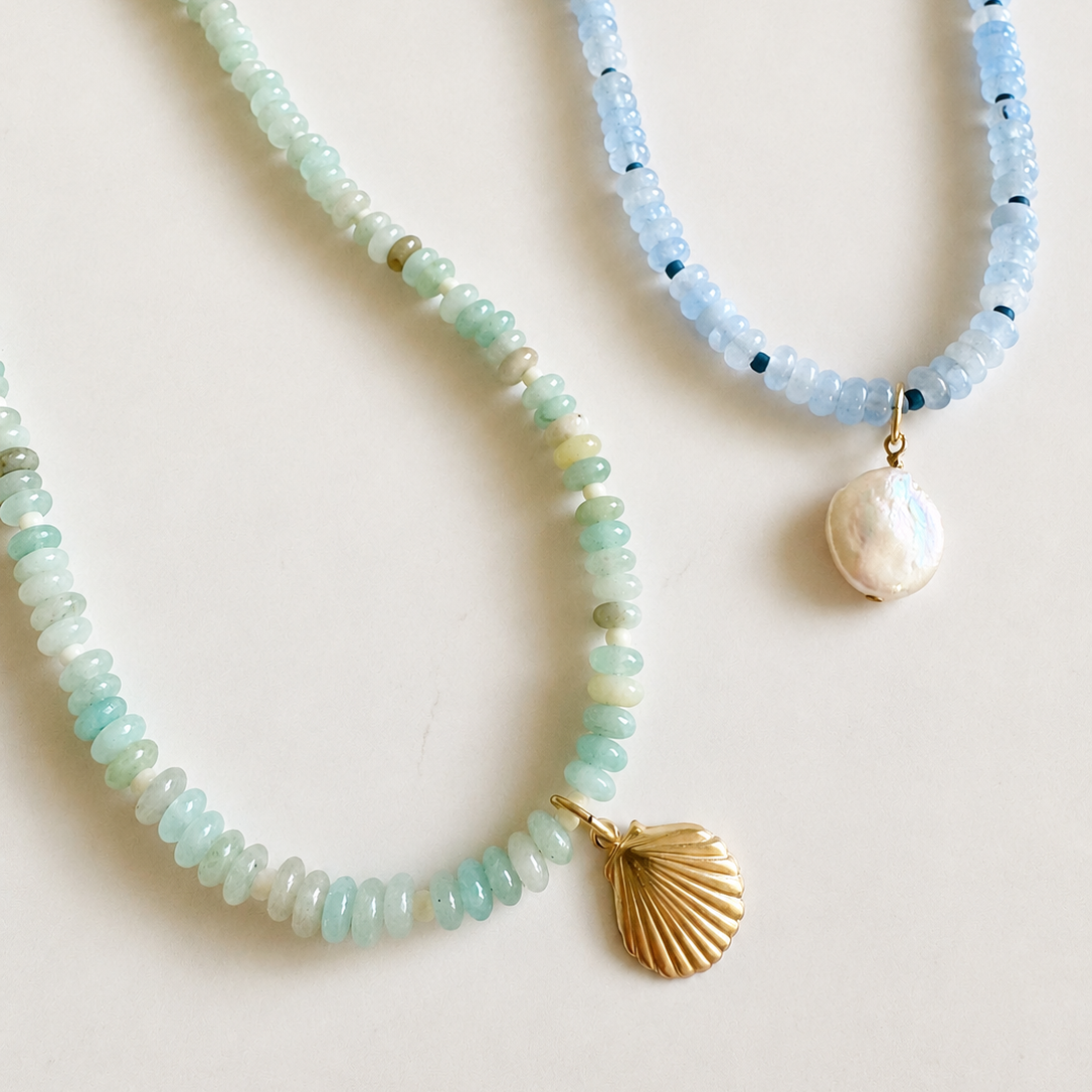 Two beaded necklaces on a light beige background. 