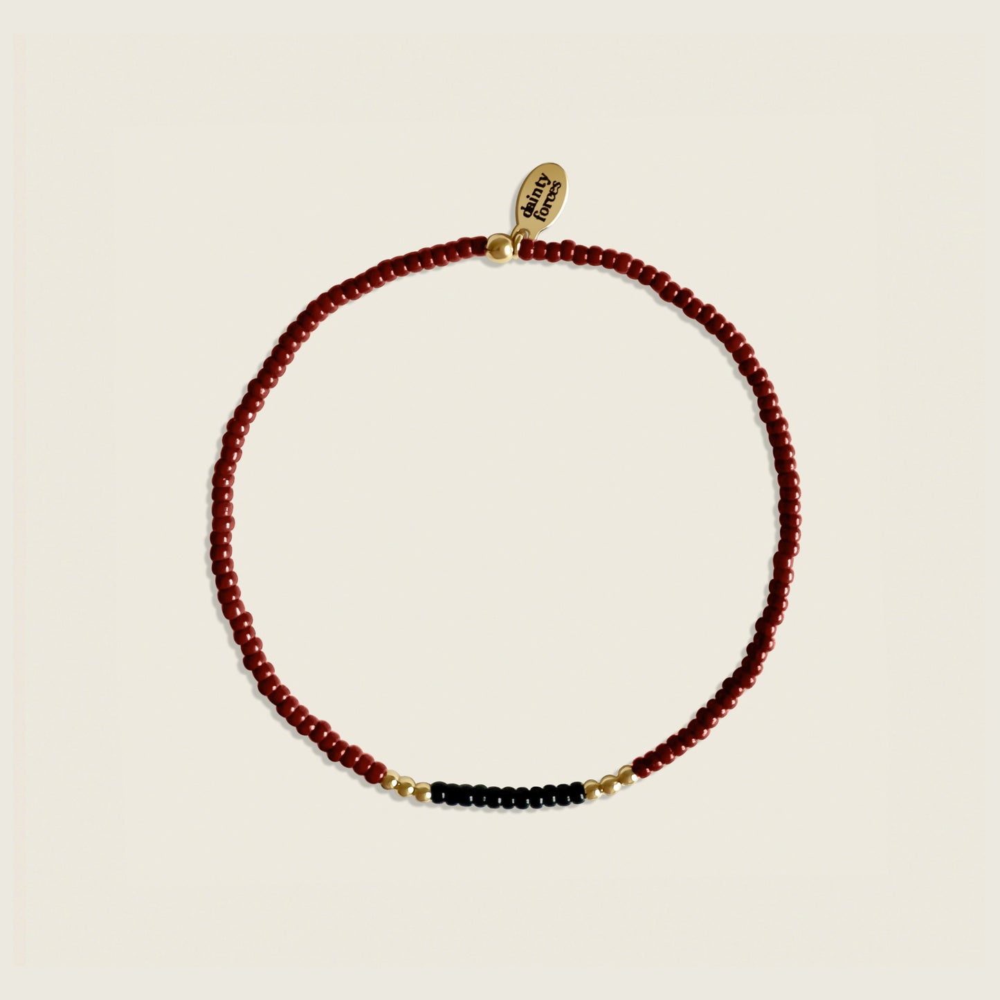 Necklace with red, black, and gold beads on a beige background